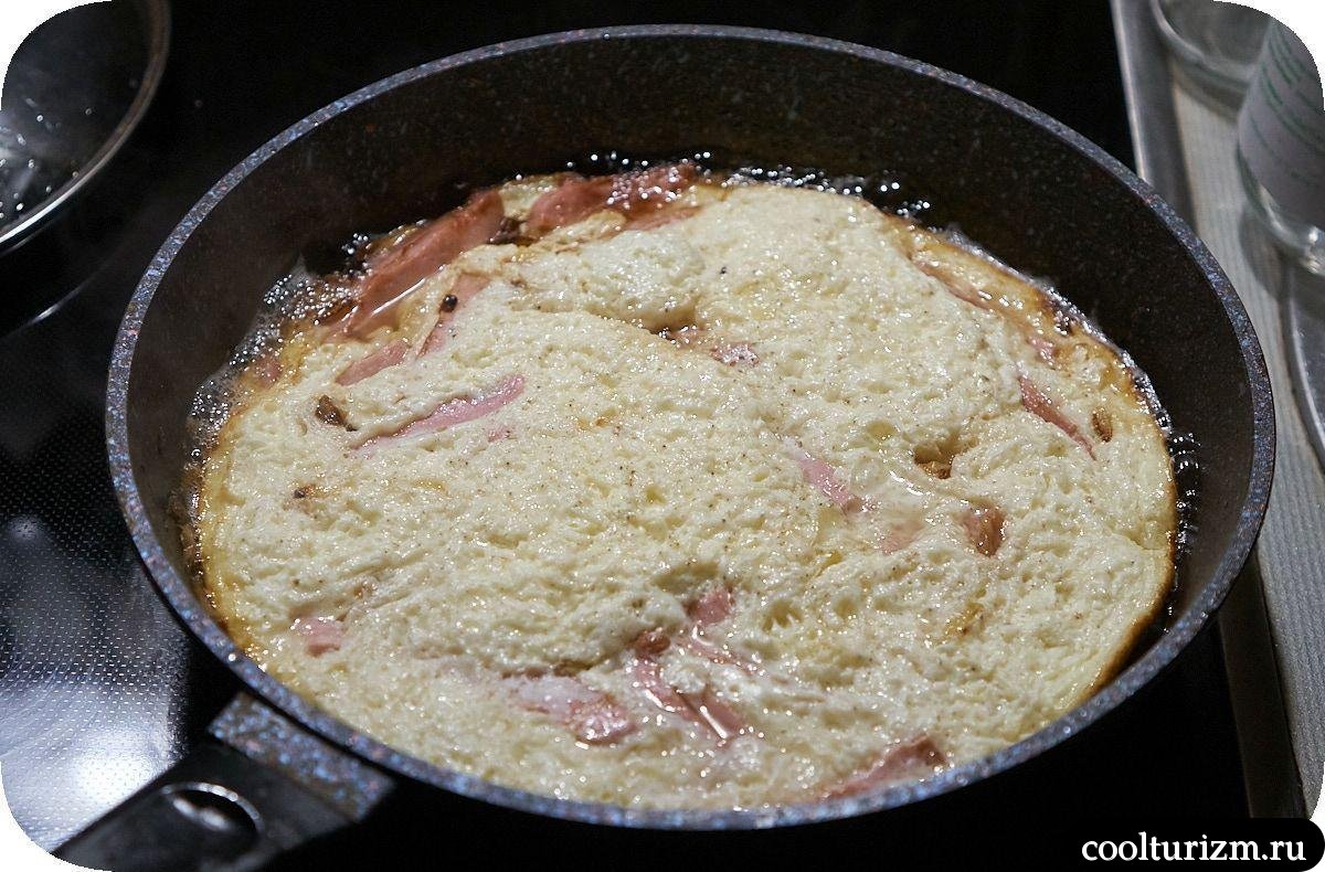 Омлет на сковороде с колбасой и луком под крышкой