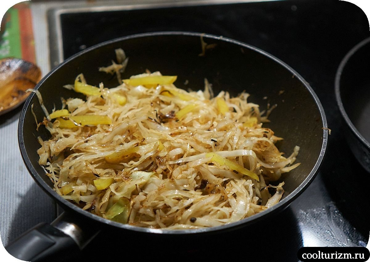 Щеки трески с тушеной капустой и яйцами на сковороде